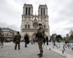 图为法国士兵在巴黎圣母院前巡逻戒备。   ( PATRICK KOVARIK/AFP/Getty Images)