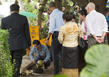 US President Barack Obama watches as a woman opens a coconut for him to drink as he makes a surprise stop for a drink alongside the Mekong River in Luang Prabang on September 7, 2016. Obama became the first US president to visit Laos in office, touching down in Vientiane late on September 5 for a summit of East and South East Asian leaders. / AFP / SAUL LOEB (Photo credit should read SAUL LOEB/AFP/Getty Images)