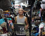 棚仔最年長的布販是83歲的陳如東，見證香港布業從全盛步向息微的歷史，他出售的布料曾被用來製作《一代宗師》電影內梁朝偉的戲服。他昨日向記者展示年輕時當模特兒的照片。（蔡雯文／大紀元）