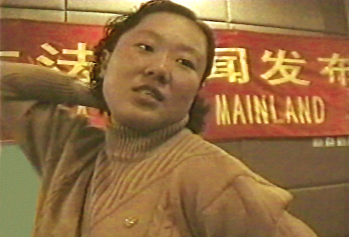 丁延在1999年10月28日的新聞發布會上，向記者描述警察用背銬的酷刑折磨法輪功學員。（明慧網）