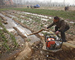 This photo taken on February 8, 2011 shows a Chinese farmer watering his drought-stricken wheat field in Luoyang, north China's Henan province, as the worst drought in six decades affecting large swathes of northern China. China called for higher rice output to offset damage to its wheat crop in the drought-stricken north and pledged $1 billion in spending to battle a problem the UN warned could be "very serious".  CHINA OUT AFP PHOTO (Photo credit should read STR/AFP/Getty Images)