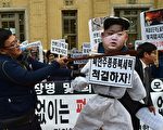 在抗議人群中，一名韓國人士用木棒打擊金正恩的紙肖像。（ JUNG YEON-JE/AFP/Getty Images)