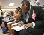 剛宣誓成為美國公民的民眾填寫選民登記表，享受身為美國公民的權利。 ( John Moore/Getty Images)