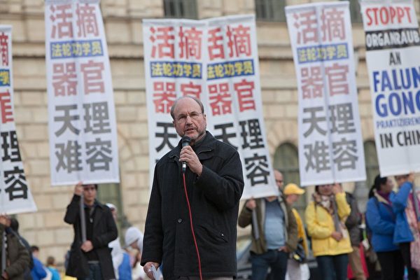 德國獨立調查員施瓦茨在慕尼黑的法輪功反迫害集會上發言,譴責西方企業為虎作倀。(傑森/大紀元)