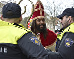 上周六在荷兰Maassluis的圣尼古拉节日欢庆中，警方正在与一名反对黑皮特的人士对话。（LEX VAN LIESHOUT/AFP/Getty Images）