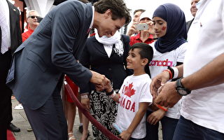 今年7月1日，总理特鲁多在国会山与参加国庆的叙利亚难民握手。（加通社）