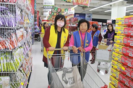 82歲的林長者 在志工陪同下購物。(郭千華/大紀元)