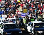 圖為2012年1月2日加州帕薩迪納玫瑰遊行期間，警車行進在抗議示威人群的前列。  (FREDERIC J. BROWN/AFP/Getty Images)