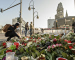 12月21日，在柏林Breitscheidplatz廣場上的聖誕市場附近，人們在地上放上了無數支蠟燭，一束束鮮花點綴其中。兩天前，一輛卡車以60多公里的時速衝進聖誕廣場，12人死亡，近50人受傷。警方聲明這是一次恐怖襲擊。凶手司機尚未抓獲。（CLEMENS BILAN/AFP/Getty Images）