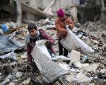 在土耳其和俄羅斯的斡旋下，敘利亞政府軍同反抗軍達成了全國停火協議，將於當地時間30日零點實現停火。圖為敘利亞男孩從建築倒塌的廢墟中撿木材，用於生火取暖和做飯。(AMER ALMOHIBANY/AFP/Getty Images)