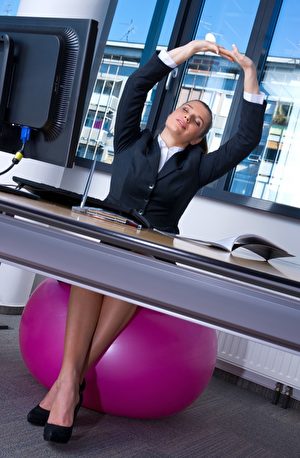 坐在鍛練球上，脊椎用力做三維的轉動。(dean bertoncelj/Shutterstock)