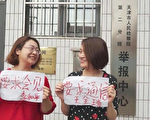 李文足（右）和709事件中同遭抓捕的李和平律師之妻——王峭嶺女士在中共天津市檢察院門前舉牌抗議。（大紀元）