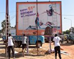 去年12月初选举结束后，在一条街上，工人们准备撤除总统贾梅（Yahya Jammeh）的竞选海报，当时贾梅在电视上承认败选。（SEYLLOU / AFP / Getty Images）