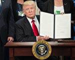 2017年1月25日，川普在椭圆形办公室签署在美墨边境建立围墙的行政令。(NICHOLAS KAMM/AFP/Getty Images)