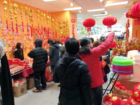 摊位上面摆满了上百张年画、对联,屋顶上还挂着各种红色宫灯。