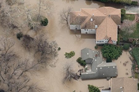 Floodwaters surround a home on February 22, 2017, in San Jose, California. Thousands of people were ordered to evacuate their homes early Wednesday in the northern California city of San Jose as floodwaters inundated neighborhoods and forced the shutdown of a major highway. / AFP PHOTO / NOAH BERGER