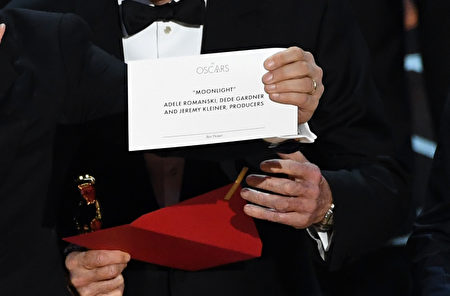 《爱乐之城》被宣布为奥斯卡最佳影片后，全体主创登台领奖，制片人霍洛维茨（Jordan Horowitz）举起印有获奖影片的卡片，宣布《月光男孩》才是大奖真正得主。(Kevin Winter/Getty Images)