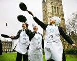 London, UNITED KINGDOM: Participants in the '2007 Parliamentary Pancake Race' undertake a practice session on College Green in aid of charity early Shrove Tuesday morning in central London, 20 February 2007. From left to right, Members of Parliament Daniel Kawczynski (L), Lindsay Hoyle (C) and Brian Iddon (R) took part in the race. The MP's won the race against a team from the House of Lords and the media. The race is in aid of charity and supports Rehab UK, a brain injury charity. AFP PHOTO/ADRIAN DENNIS 2007年，议员们在议会大厦前的维多利亚塔花园（Victoria Tower Garden）前投掷平锅中的煎饼的历史照片。（ ADRIAN DENNIS/AFP/Getty Images)
