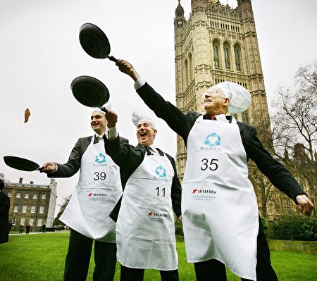  2007年，议员们在议会大厦前的维多利亚塔花园（Victoria Tower Garden）前投掷平锅中的煎饼。（ ADRIAN DENNIS/AFP/Getty Images)
