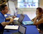 民眾正在跟健保公司員工咨詢投保事宜。 (Joe Raedle/Getty Images)