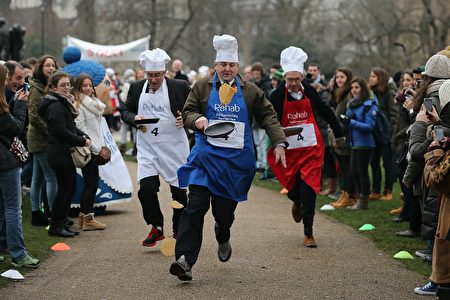 LONDON, ENGLAND - FEBRUARY 12: The annual Parliamentary Pancake Race takes place in front of the Houses of Parliament on Shrove Tuesday on February 12, 2013 in London, England. Now in it's 16th year, the annual Pancake Race, which raises money for the charity Rehab, sees teams of politicians and journalists racing in a circuit whilst tossing pancakes in frying pans. The team of MPs won this year's event. (Photo by Dan Kitwood/Getty Images)