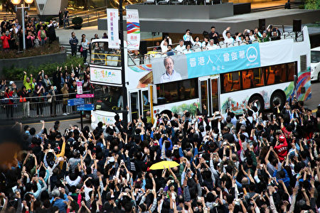 星期五，距離香港行政長官選舉倒數二日，候選人曾俊華舉行巴士巡遊造勢活動，所到之處都受到許多香港市民的歡迎和與他拍照留念。(李逸/大紀元)