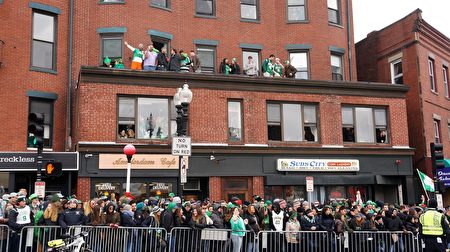 穿戴著翡翠綠服飾、佩帶著三葉苜蓿的當地居民和遊客，觀看波士頓聖派翠克節遊行。（貝拉/大紀元）