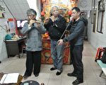 理事長林周平（中）、總幹事馬水城與財務長陳進財（右）把玩當年國樂社樂器。（周美晴／大紀元）