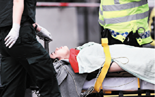 伦敦议会大厦恐怖袭击中，受伤的中国女孩被救护人员放在担架上推走。（Carl Court/Getty
Images）