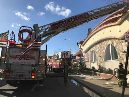 法拉盛緬街夾60街的新東雲閣酒樓火災，火警從二級升至五級，消防局架起雲梯滅火。