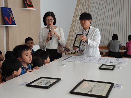 插畫家yuchen（執麥克風者）在「閒畫嘉常‧擁抱愛」插畫展記者會上，為貴賓及小朋友介紹畫作。（蔡上海／大紀元）