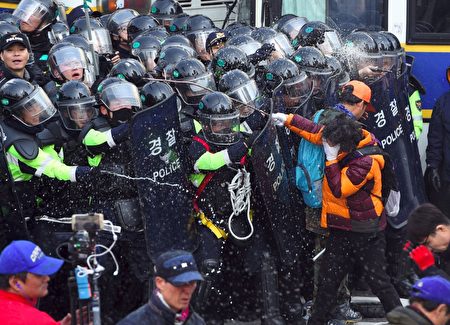 韩国总统朴槿惠的弹劾案确认通过后，场外不同立场的民众爆发冲突，与警察对峙。（Chung Sung-Jun / Getty Images）