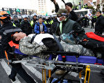 韩国总统朴槿惠的弹劾案确认通过后，场外不同立场的民众爆发冲突，多人受伤，2人死亡。图为现场受伤民众。（Chung Sung-Jun / Getty Images）