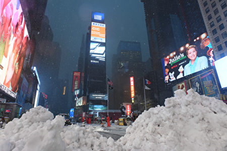 Piles of snow are seen as workers clear the sidewalks in Times Square during a snowstorm in New York on March 14, 2017. Winter Storm Stella dumped snow and sleet Tuesday across the northeastern United States where thousands of flights were canceled and schools closed, but appeared less severe than initially forecast. After daybreak the National Weather Service (NWS) revised down its predicted snow accumulation for the city of New York, saying that the storm had moved across the coast. / AFP PHOTO / Eric BARADAT (Photo credit should read ERIC BARADAT/AFP/Getty Images)