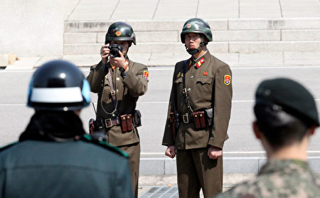 在三八線另一端的朝鮮士兵則密切注視，有士兵舉相機拍攝蒂勒森一行人。(Photo credit should read LEE JIN-MAN/AFP/Getty Images)