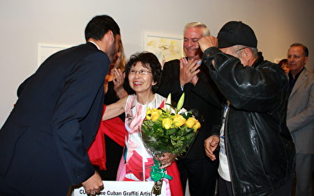 古巴艺术家“良心犯”达尼洛．马尔多纳多（左一）赠花感谢维权人士刘雅雅（左二）声援协助。（徐绣惠／大纪元）