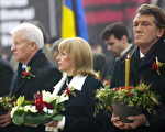 2006年11月25 日，烏克蘭總統尤先科（右）主持「1932—1933年大饑荒檔案揭密展」。民眾點燃蠟燭悼念在斯大林暴政下的死難者。(GENIA SAVILOV/AFP/Getty Images)