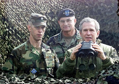 US President George W. Bush (R) looks across the demilitarized zone into North Korea through a bullet proof glass from Outpost Ouellette, a US Military base in the demilitarized zone between South and North Korea, 20 February 2002. At left is Lt. Col. William Miller, commander joint security area, and at center is General Thomas Schwartz, commander in charge of the US forces in Korea. Bush accused North Korean leader Kim Jong-Il, during a joint press conference with his South Korean counterpart Kim Dae-Jung, of abusing his people but said the US would not invade the North. Bush is here for a three-day official visit as part of his three Asian nations tour. AFP PHOTO by Luke FRAZZA / AFP PHOTO / LUKE FRAZZA