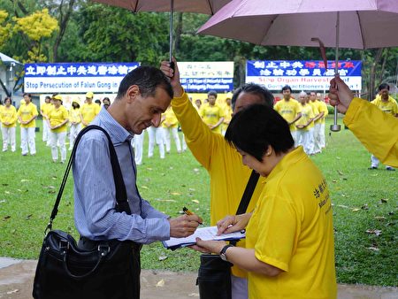 2017年4月18日，新加坡部份法輪功學員，冒著小雨在芳林公園舉行集體煉功、征簽等活動，紀念「四二五」萬名法輪功學員和平上訪18週年。（Tony／大紀元） 