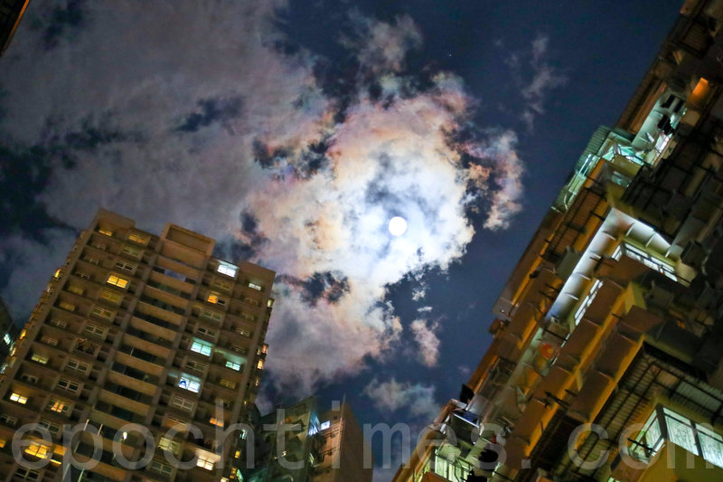 香港稠密高樓群的特殊景觀,曾是好萊塢電影變形金鋼、攻殻機動隊等影片的取景場地之一。圖為2017年4月8日晚,香港鰂魚涌高樓群在明月相伴下,彩雲片片的美景。(余鋼/大紀元)