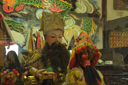 有位古董商的信众，提供不同奉献，给大尊神像头戴官帽，传说是明朝末年皇帝的真品，对于信众的虔诚，国姓爷是台湾最盛行的信仰之一。（詹亦菱／大纪元）