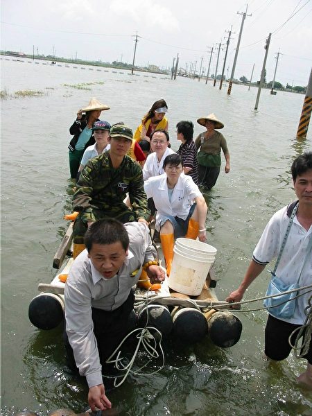 2005年612水災，朴子醫院醫護人員涉水深入災區救災的鏡頭。（朴子醫院提供）