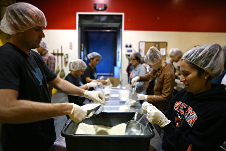 义工在为低收入户准备食物。(Justin Sullivan/Getty Images)