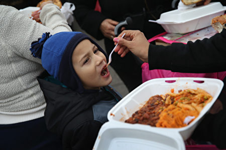纽约布鲁克林区低收入户家庭孩童在享用免费食物。(John Moore/Getty Images)