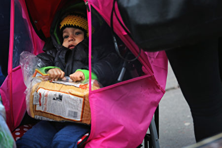 孩童拿到免费的土司。(John Moore/Getty Images)