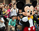 去年6月上海迪士尼乐园开幕，游客观看游行。(JOHANNES EISELE/AFP/Getty Images)