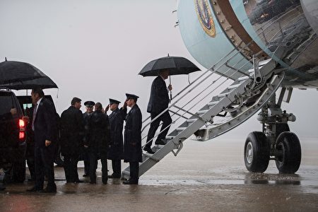 在马里兰州安德鲁斯空军基地，川普在雨中登上“空军一号”飞往佛州。 (Photo credit should read JIM WATSON/AFP/Getty Images)
