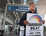 4月12日在芝加哥奧黑而國際機場，一位抗議者向美聯航將乘客趕下客艙的做法示威。示威牌寫道：你應該擊敗的是對手，而不是客戶。(Scott Olson/Getty Images)