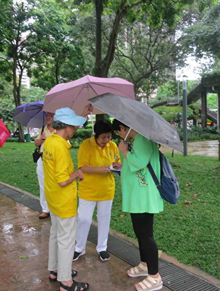 2017年4月18日，新加坡部分法輪功學員，冒著小雨在芳林公園舉行集體煉功、徵簽等活動，紀念「四•二五」萬名法輪功學員和平上訪十八週年。（王秀/大紀元）