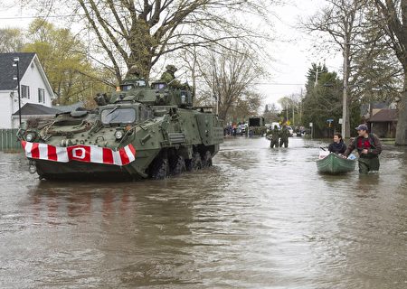 5月8日，加拿大軍隊進入蒙特利爾西北的雙山（Deux-Montagnes）市遭水淹的街道救援。（加通社）
